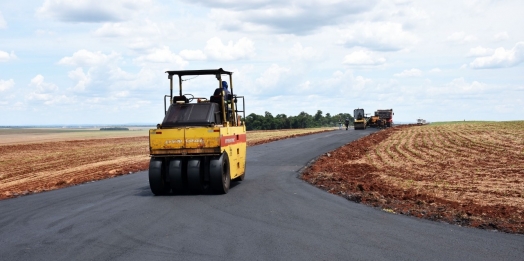 Estrada de acesso à Vila Rural começa a receber a aplicação de massa asfáltica